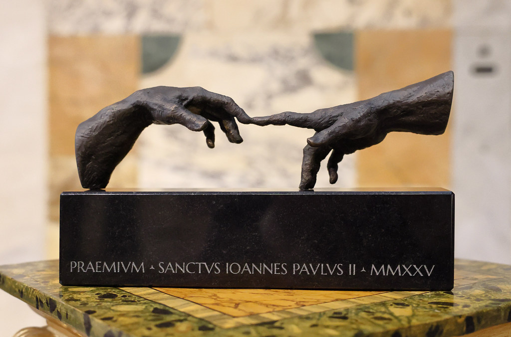 Premio San Giovanni Paolo II award statuette depicting two hands reaching towards each other